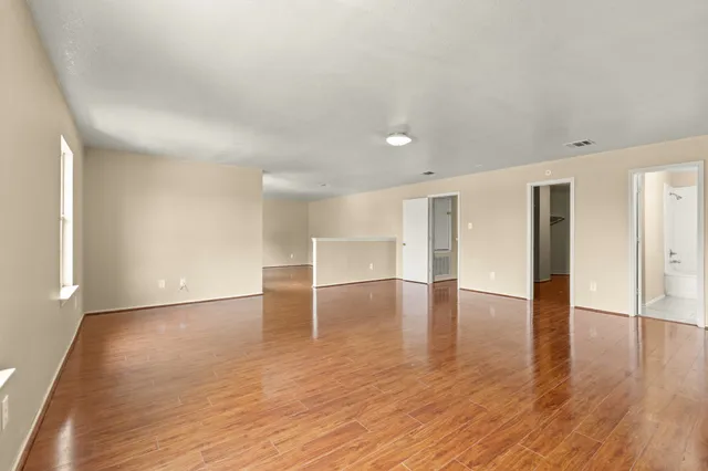 a view of empty room with wooden floor