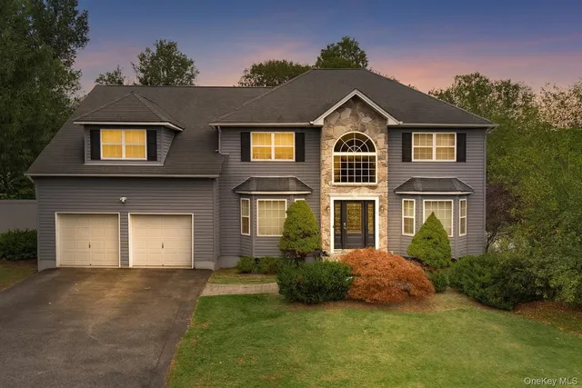 a front view of a house with a yard and garage