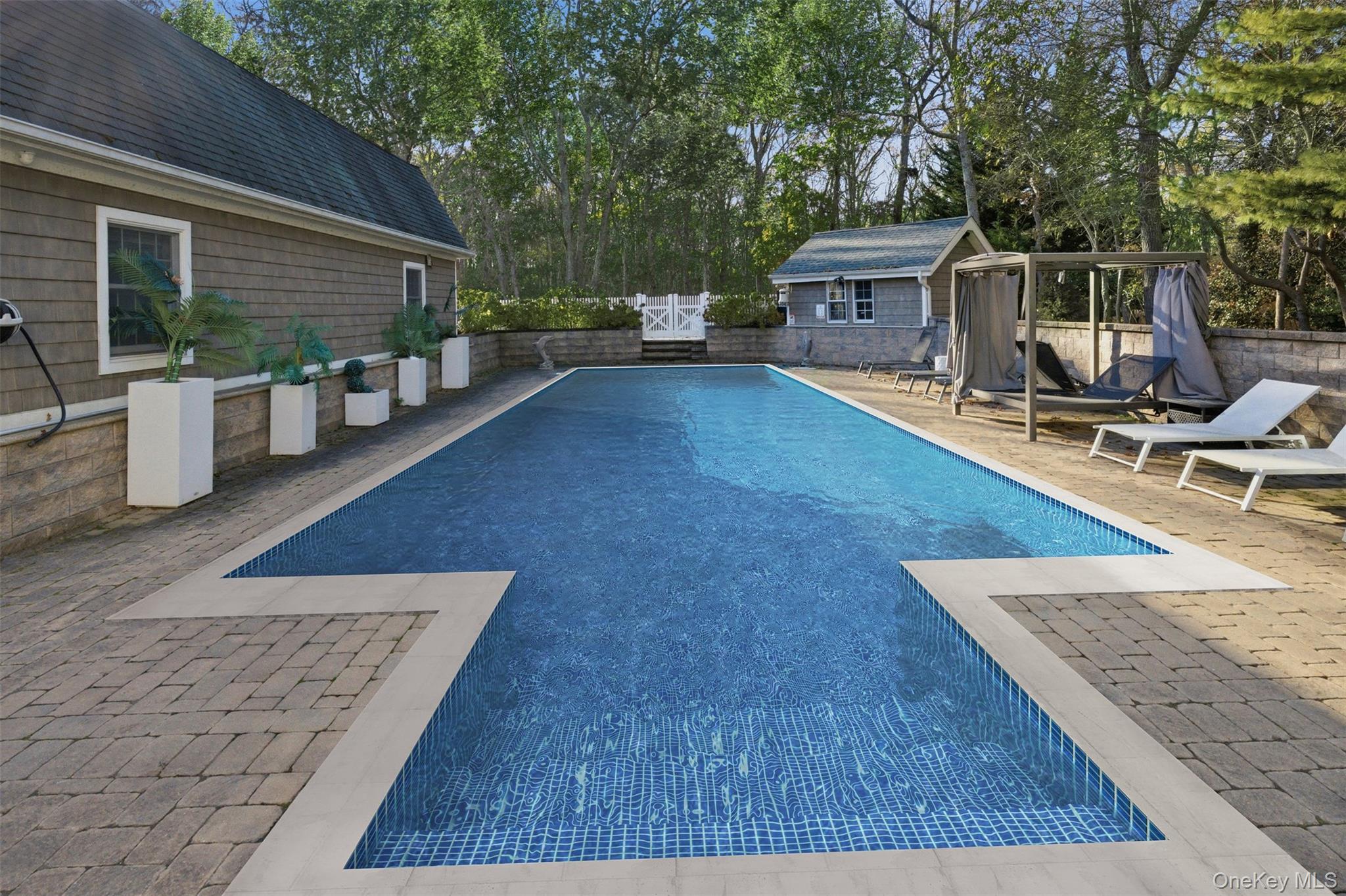 33 A Newtown Road Hampton Bays, NY 11946 - Photo 11 of 50 View of pool with a patio area, a fenced backyard, an outbuilding, and view of wooded area