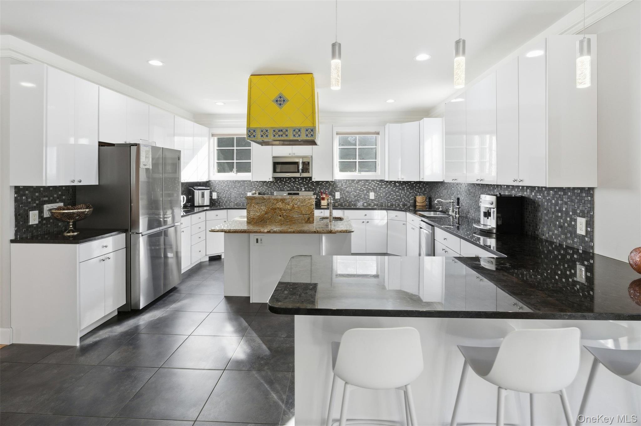 33 A Newtown Road Hampton Bays, NY 11946 - Photo 24 of 50 a kitchen with stainless steel appliances granite countertop a table chairs sink refrigerator and microwave