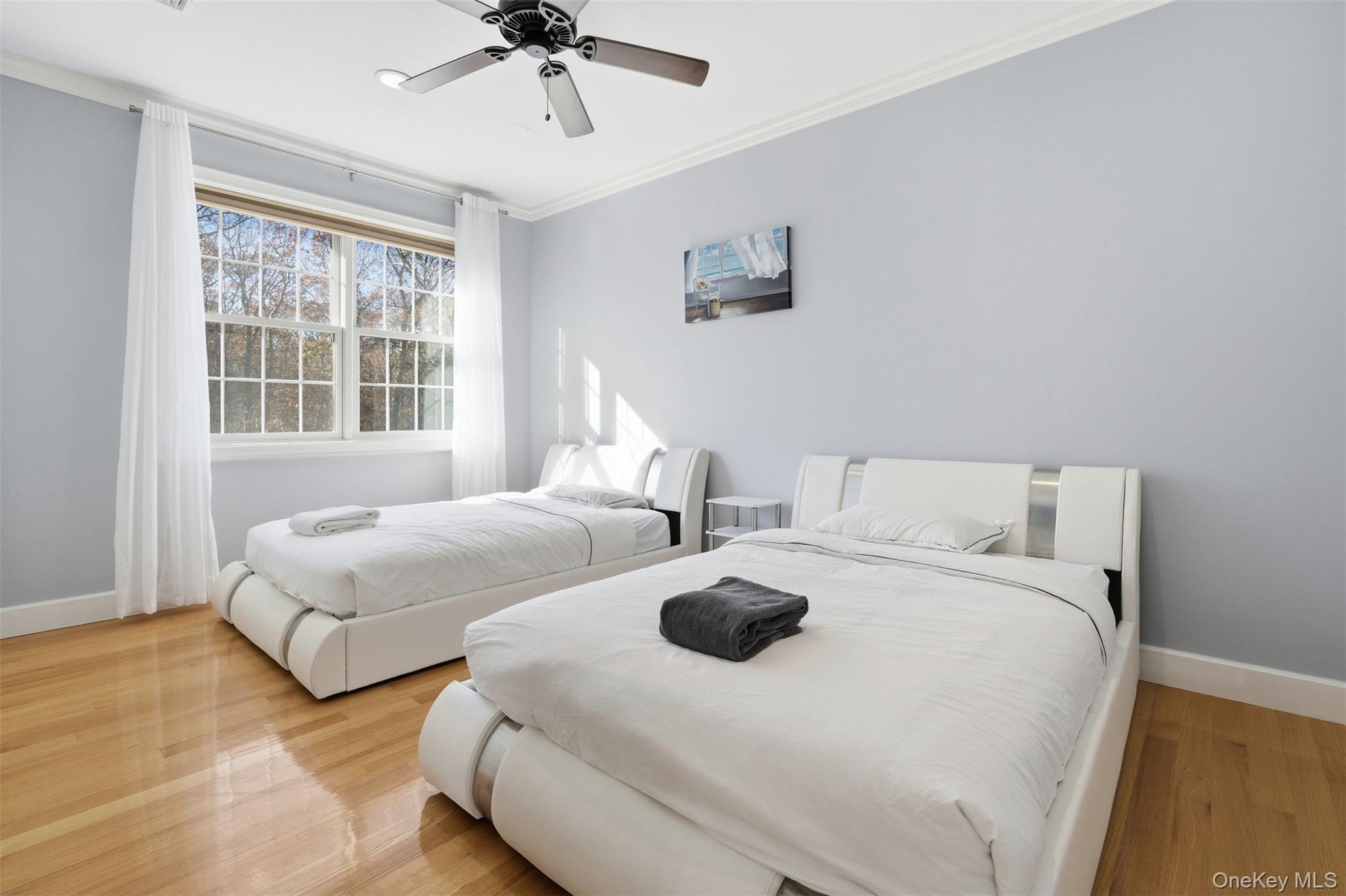 33 A Newtown Road Hampton Bays, NY 11946 - Photo 36 of 50 a bedroom with two beds and a chandelier