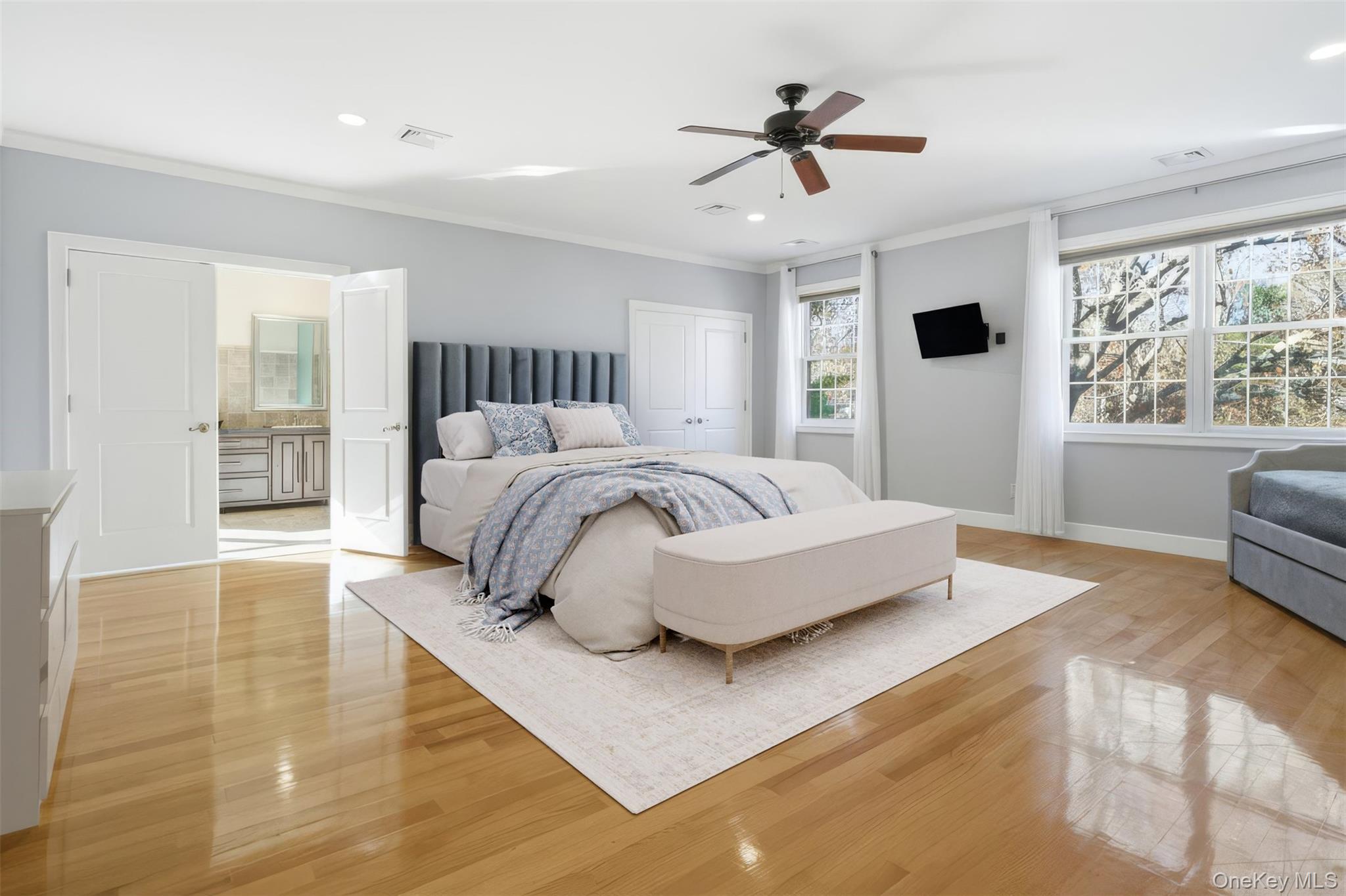 33 A Newtown Road Hampton Bays, NY 11946 - Photo 38 of 50 a spacious bedroom with a large bed a chandelier and windows