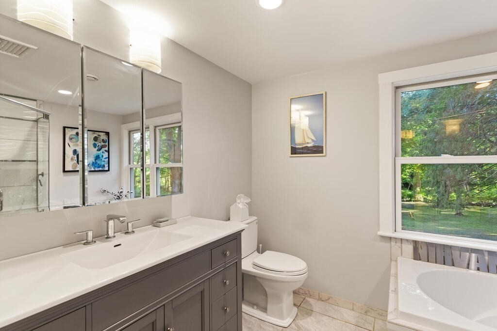 15 Labor In Vain Road Ipswich, MA 01938 - Photo 25 of 37 a bathroom with a toilet a sink a mirror a window and vanity