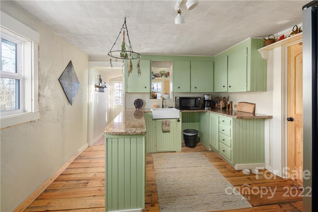 20 Indian Camp Branch Road Weaverville, NC 28787 - Photo 13 of 18 a room with kitchen island a sink wooden floor and living room view
