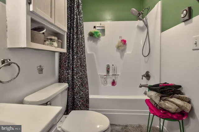 a bathroom with a toilet and a shower curtain