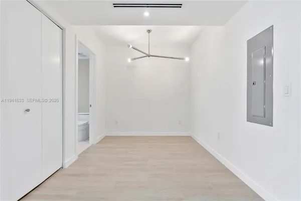 en empty room with floor to ceiling window and wooden floor