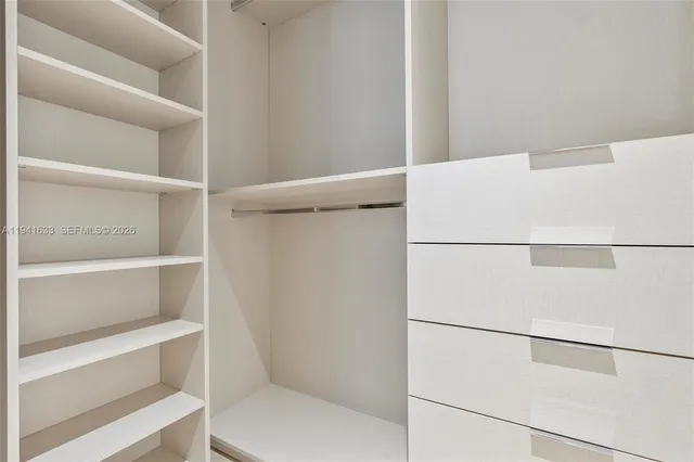 a view of walk in closet with empty racks