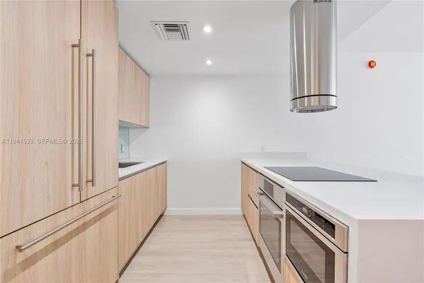 a kitchen with white cabinets and sink