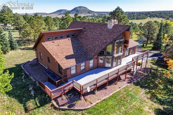an aerial view of a house with swimming pool and a yard
