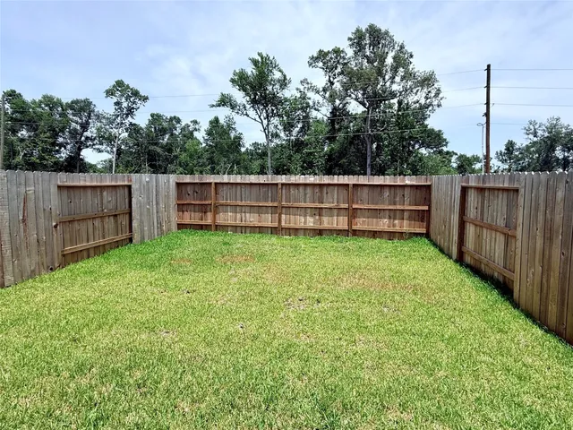 a view of a backyard with a small cabin and wooden fence