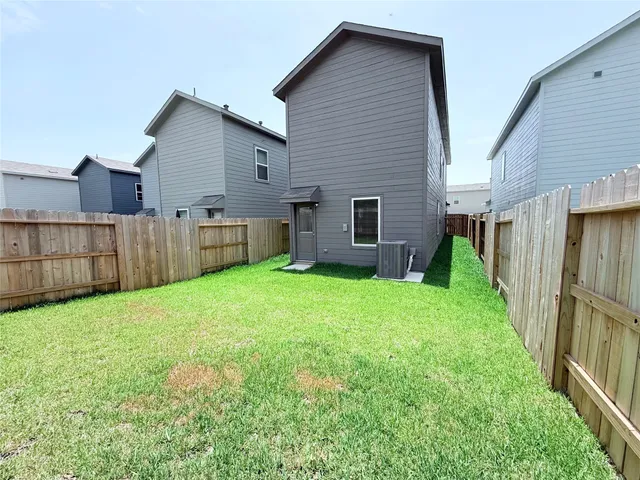a view of a house with backyard and wooden fence