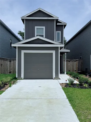 a front view of a house with a garden and plants