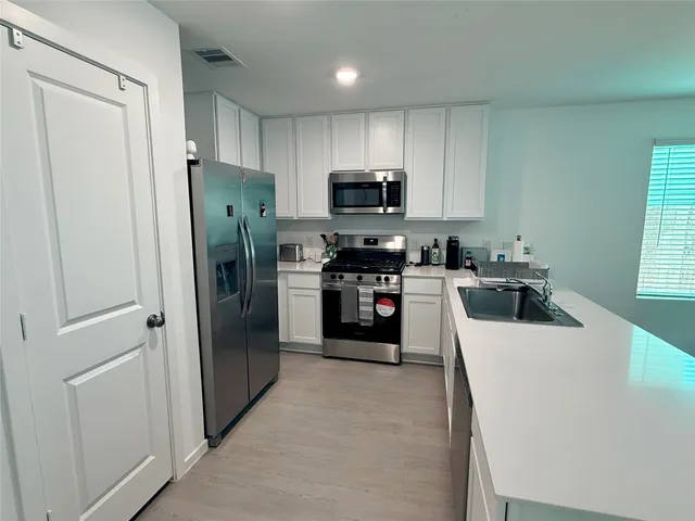a kitchen with refrigerator a sink and cabinets