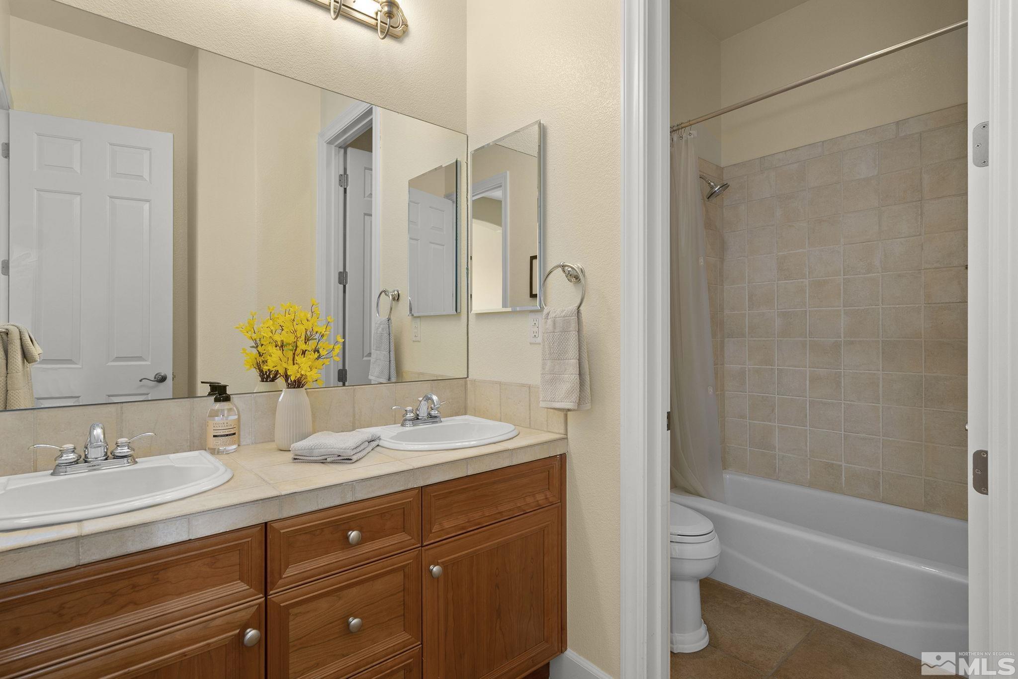 15300 Redmond Loop Reno, NV 89511 - Photo 26 of 38 a bathroom with a granite countertop sink toilet and shower