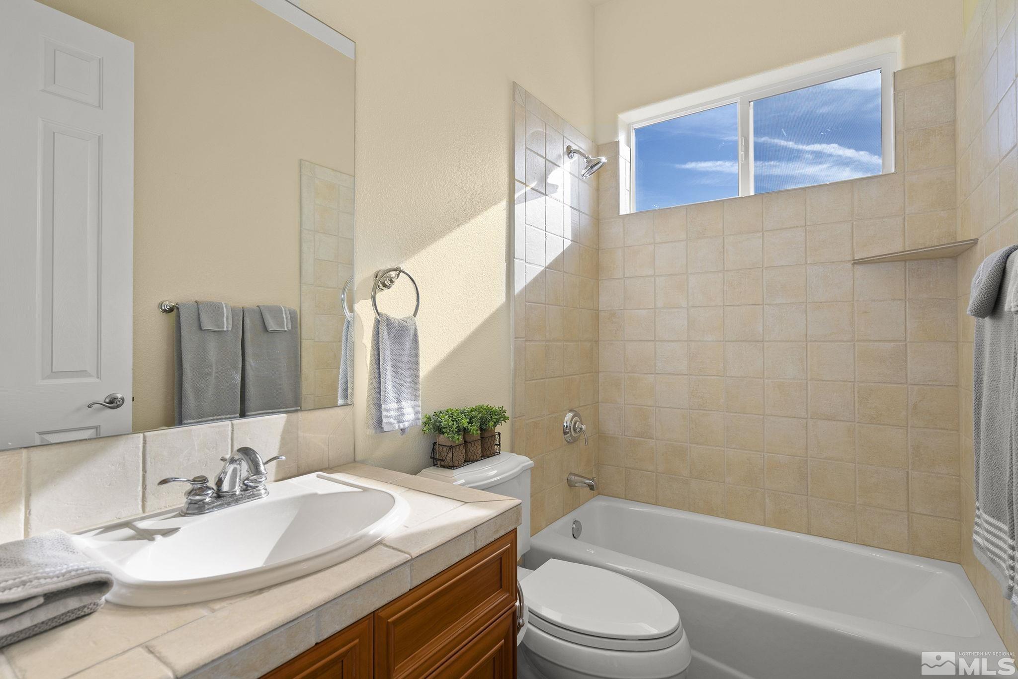 15300 Redmond Loop Reno, NV 89511 - Photo 30 of 38 a bathroom with a granite countertop bathtub sink vanity mirror and toilet