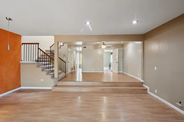 a view of a livingroom with a ceiling fan & entryway