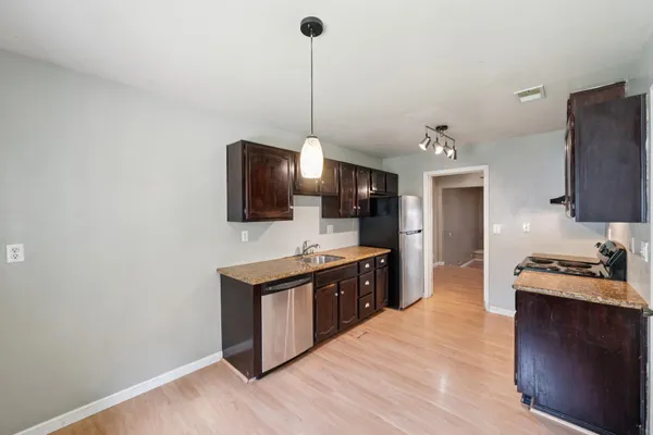 a kitchen with stainless steel appliances granite countertop a stove a sink and a refrigerator