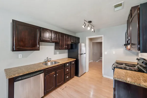 a kitchen with stainless steel appliances granite countertop a sink stove and refrigerator