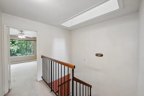 an empty room with a ceiling fan and a window