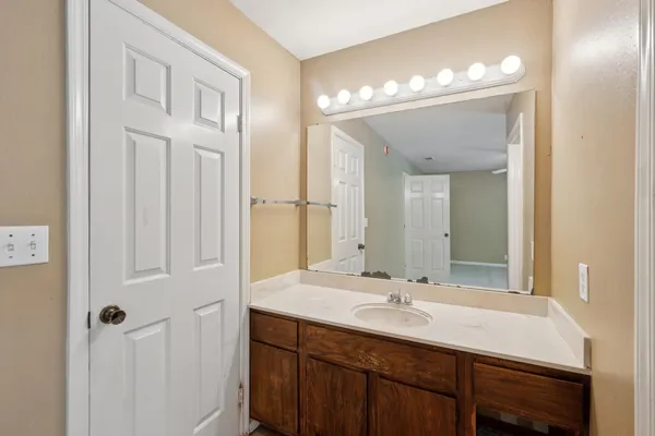 a bathroom with a bathtub shower sink and mirror