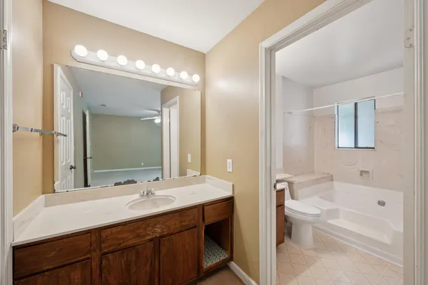 a white bath tub sitting next to a white sink and vanity
