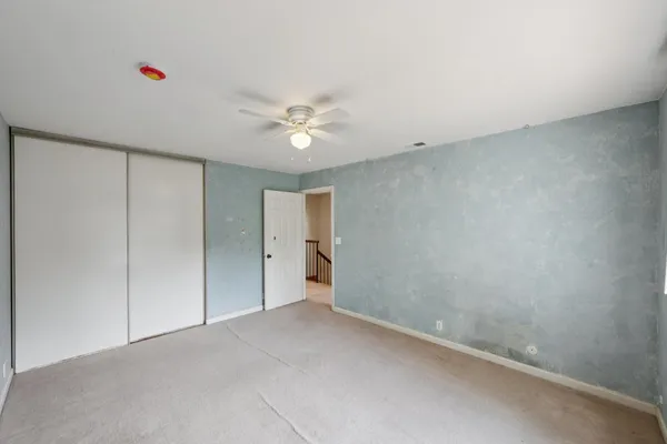 a view of a room with a ceiling fan and a window