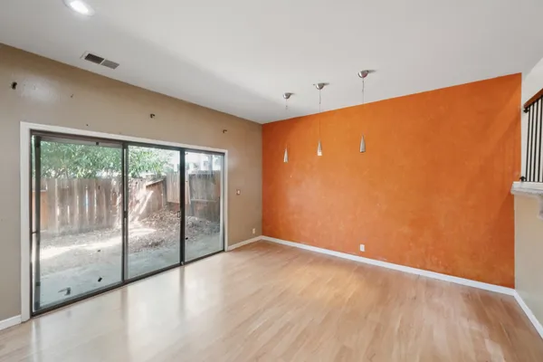 a view of empty room with wooden floor and fireplace