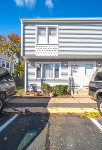 a view of a house with cars parked on the road
