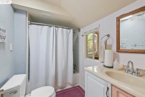 a bathroom with a granite countertop sink toilet and mirror