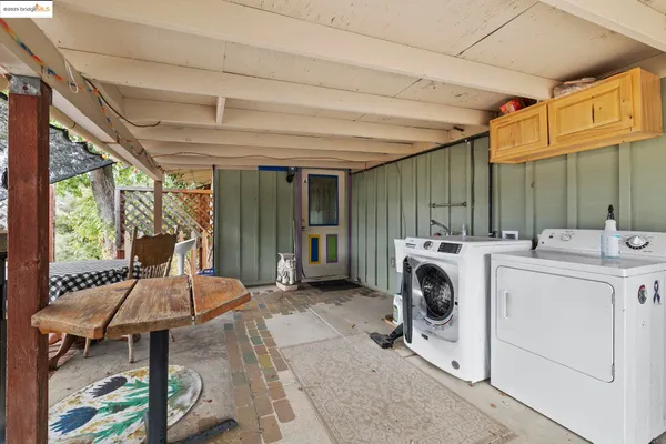 a utility room with dryer washer and a view of living room