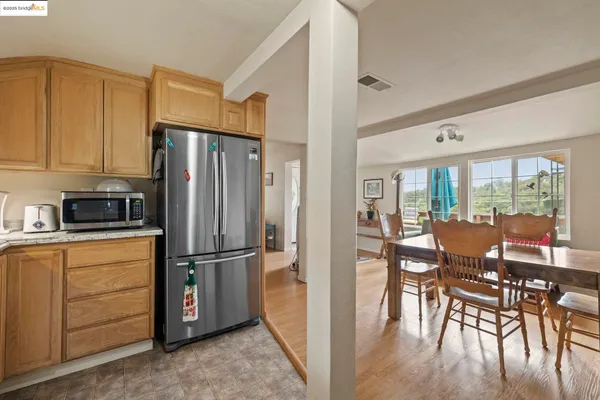 a kitchen with stainless steel appliances granite countertop a refrigerator and wooden floor