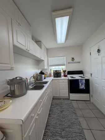 a kitchen with stainless steel appliances a stove a sink and white cabinets
