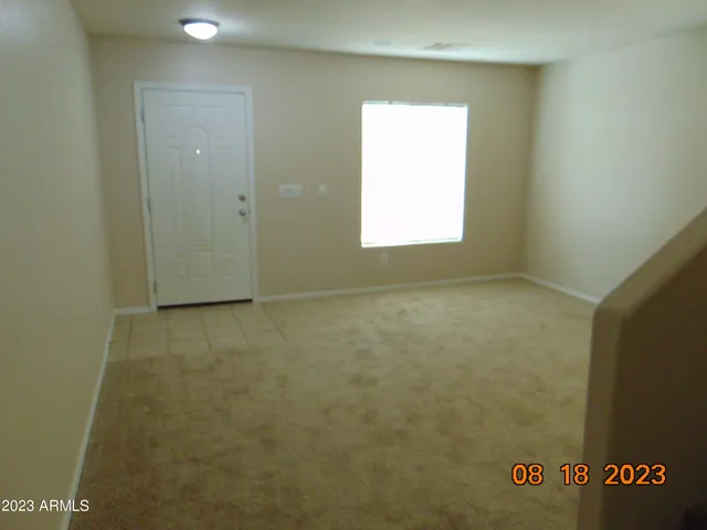 a view of a hallway with closet and window