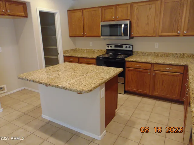 a kitchen with granite countertop wooden cabinets and a stove