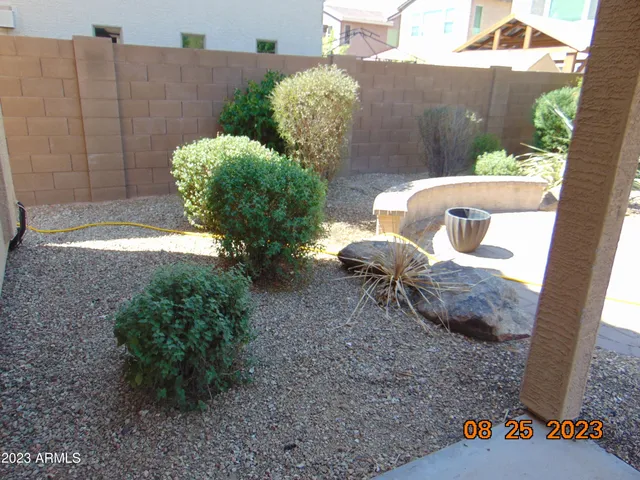 a backyard of a house with table and chairs