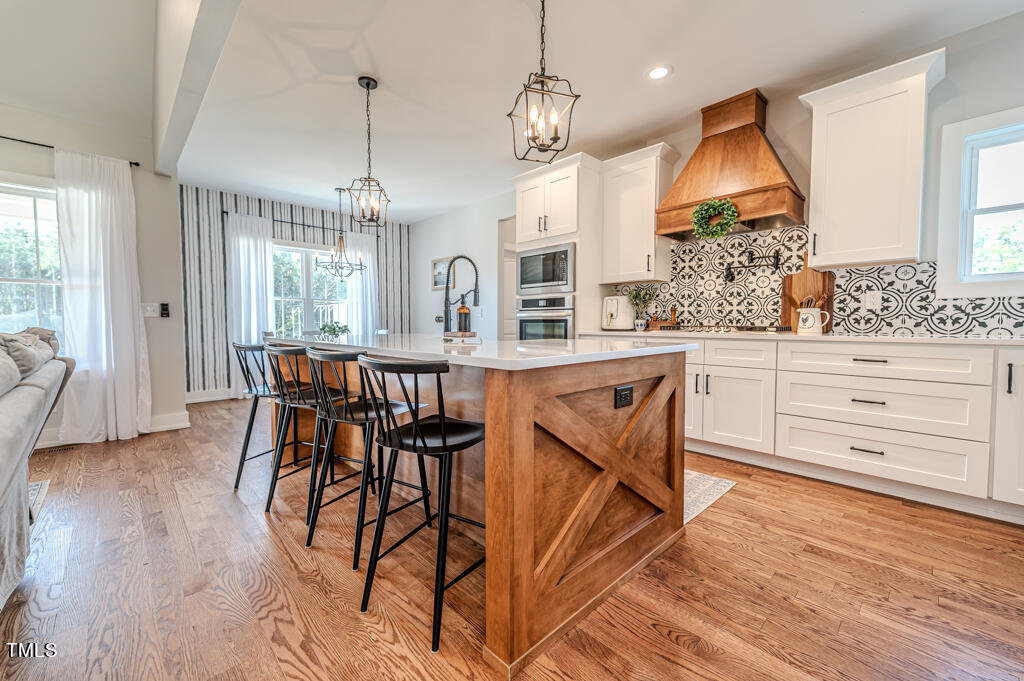 997 Jackson Road Fuquay-Varina, NC 27526 - Photo 24 of 75 a open kitchen with stainless steel appliances granite countertop a kitchen island a stove a table and chairs in it