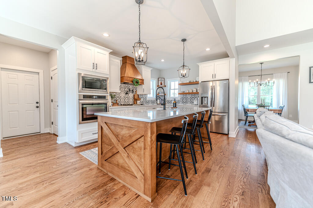 997 Jackson Road Fuquay-Varina, NC 27526 - Photo 31 of 75 a view of a dining room and livingroom with furniture wooden floor a chandelier
