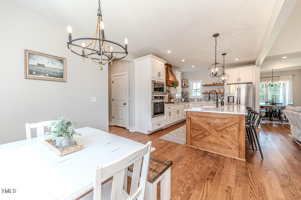 997 Jackson Road Fuquay-Varina, NC 27526 - Photo 37 of 75 a living room with kitchen island furniture and a chandelier