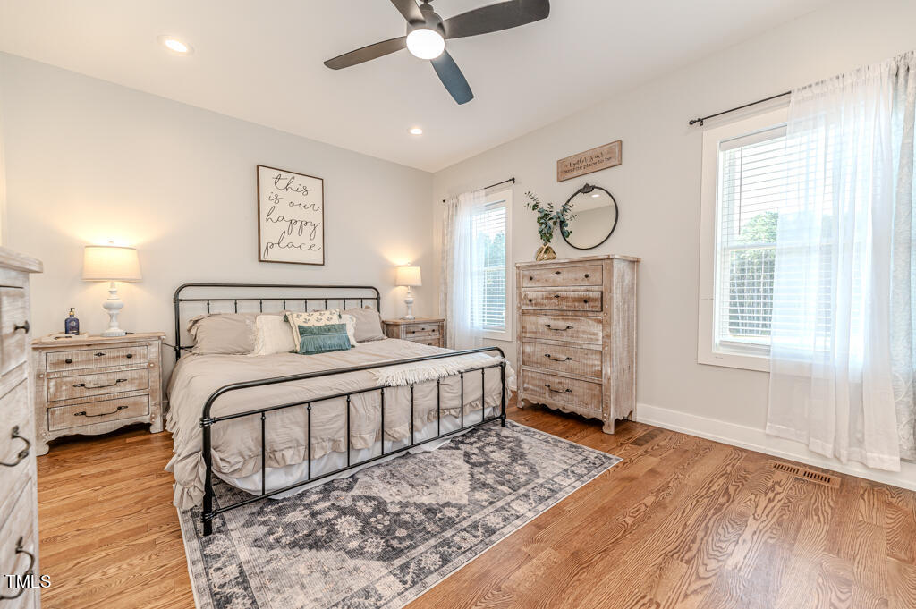 997 Jackson Road Fuquay-Varina, NC 27526 - Photo 51 of 75 a bedroom with a bed a dresser and next to a window