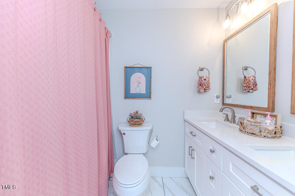997 Jackson Road Fuquay-Varina, NC 27526 - Photo 60 of 75 a white toilet sitting next to a bathroom sink