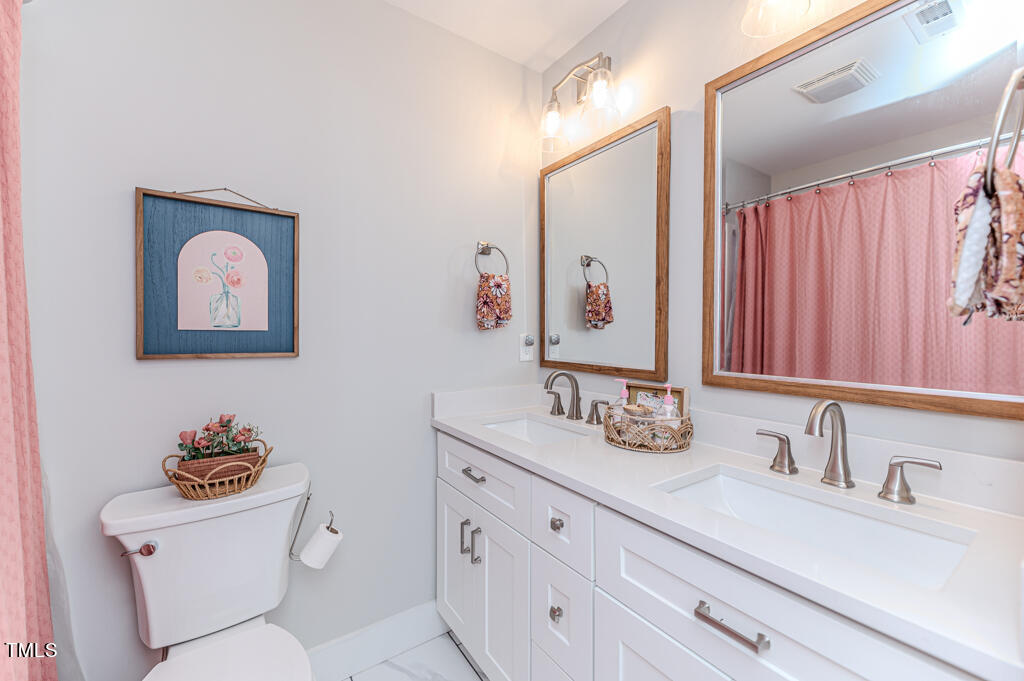 997 Jackson Road Fuquay-Varina, NC 27526 - Photo 61 of 75 a bathroom with a toilet sink and mirror