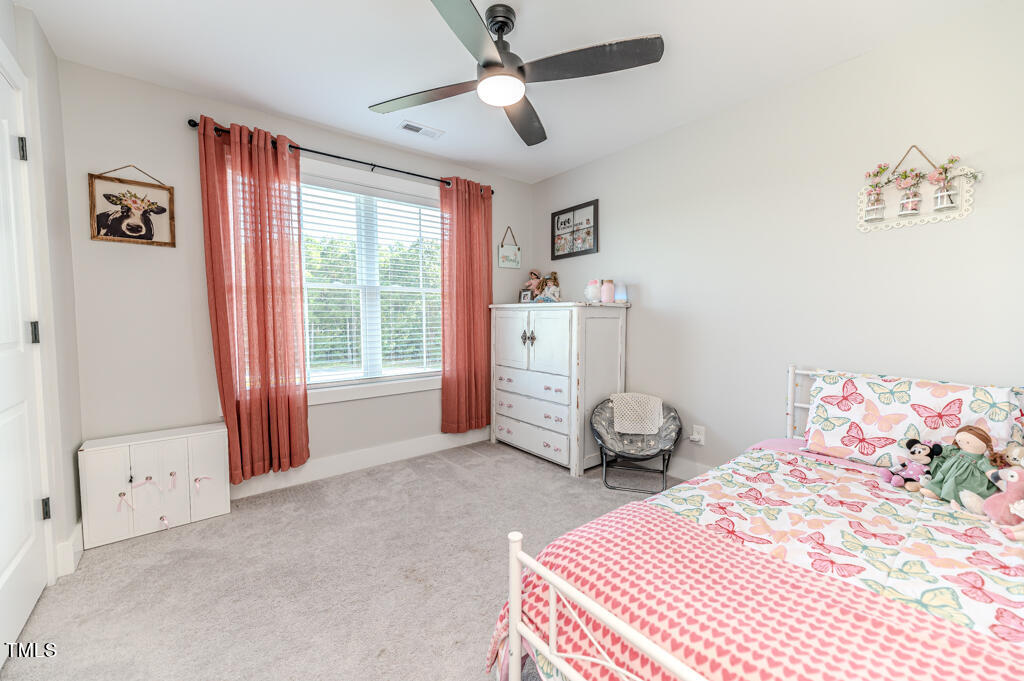 997 Jackson Road Fuquay-Varina, NC 27526 - Photo 63 of 75 a bedroom with a bed and a chandelier