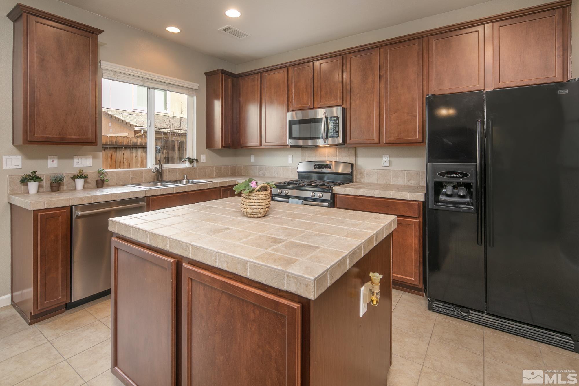 2093 Waterhouse Road Reno, NV 89521 - Photo 12 of 30 a kitchen with a sink a refrigerator and cabinets