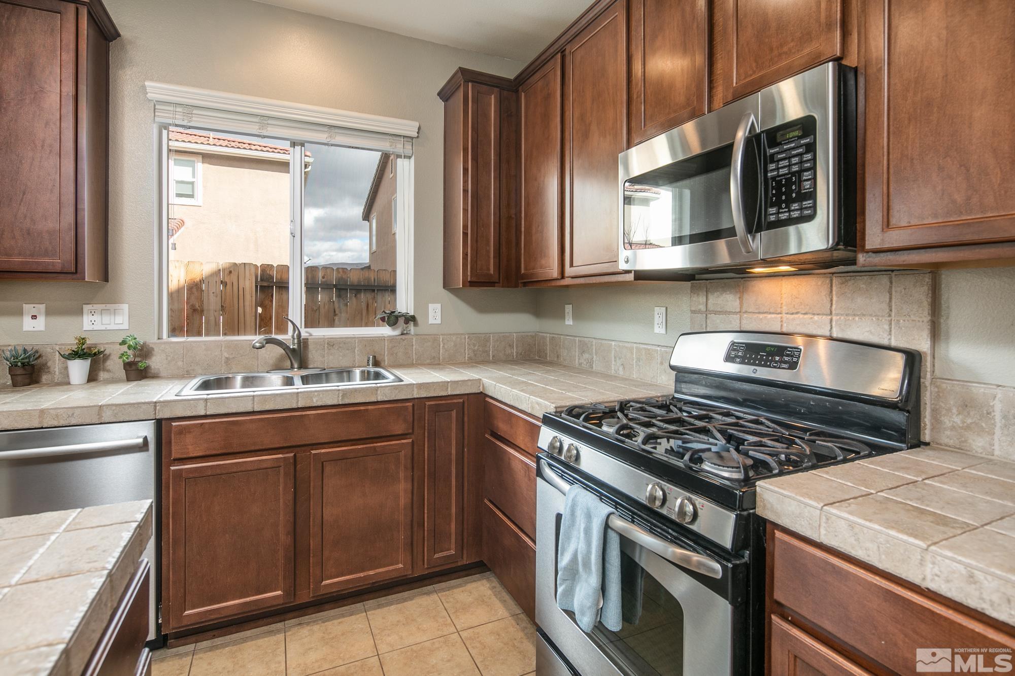 2093 Waterhouse Road Reno, NV 89521 - Photo 13 of 30 a kitchen with stainless steel appliances granite countertop a stove a sink and a microwave