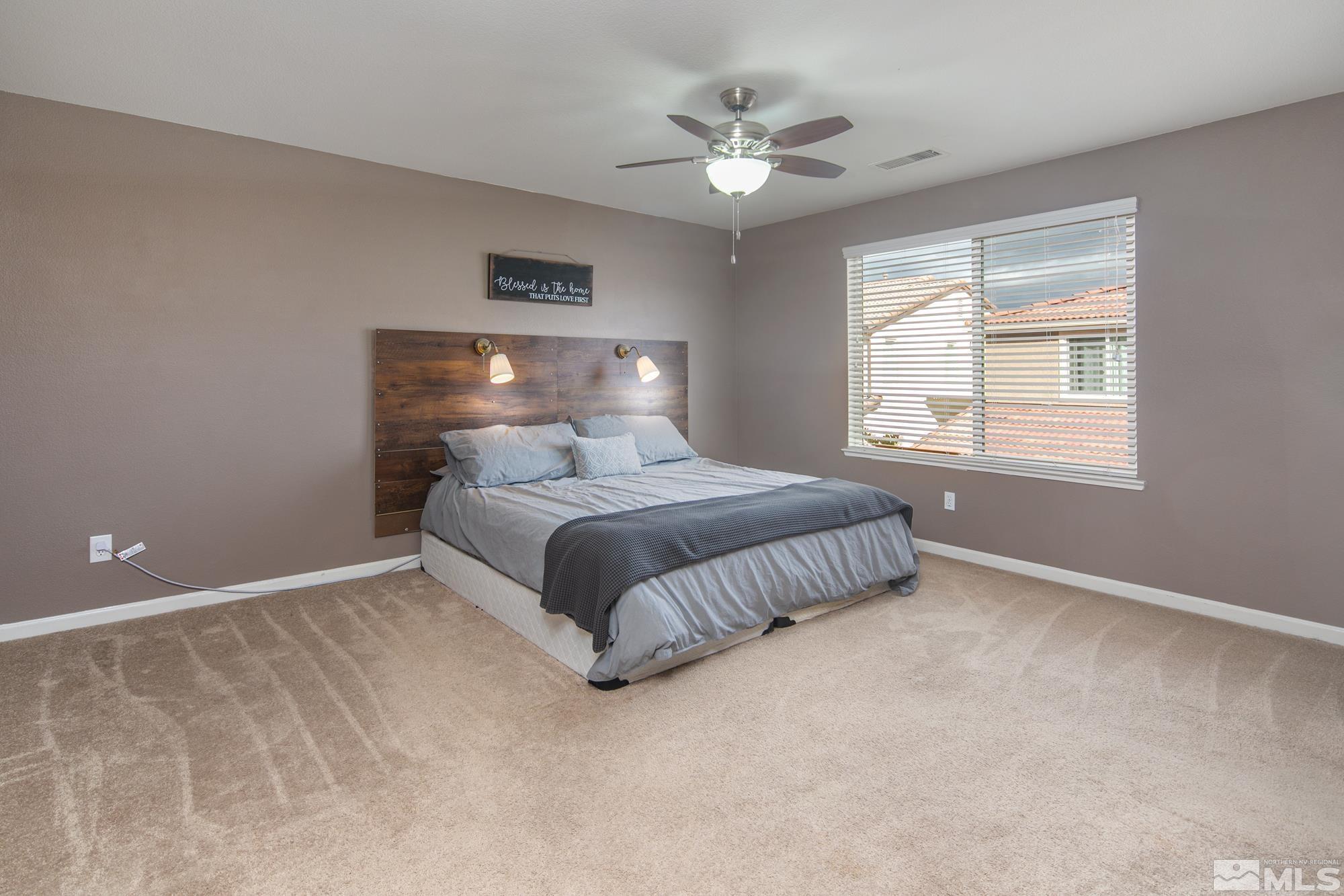 2093 Waterhouse Road Reno, NV 89521 - Photo 22 of 30 a bedroom with a bed chandelier and window