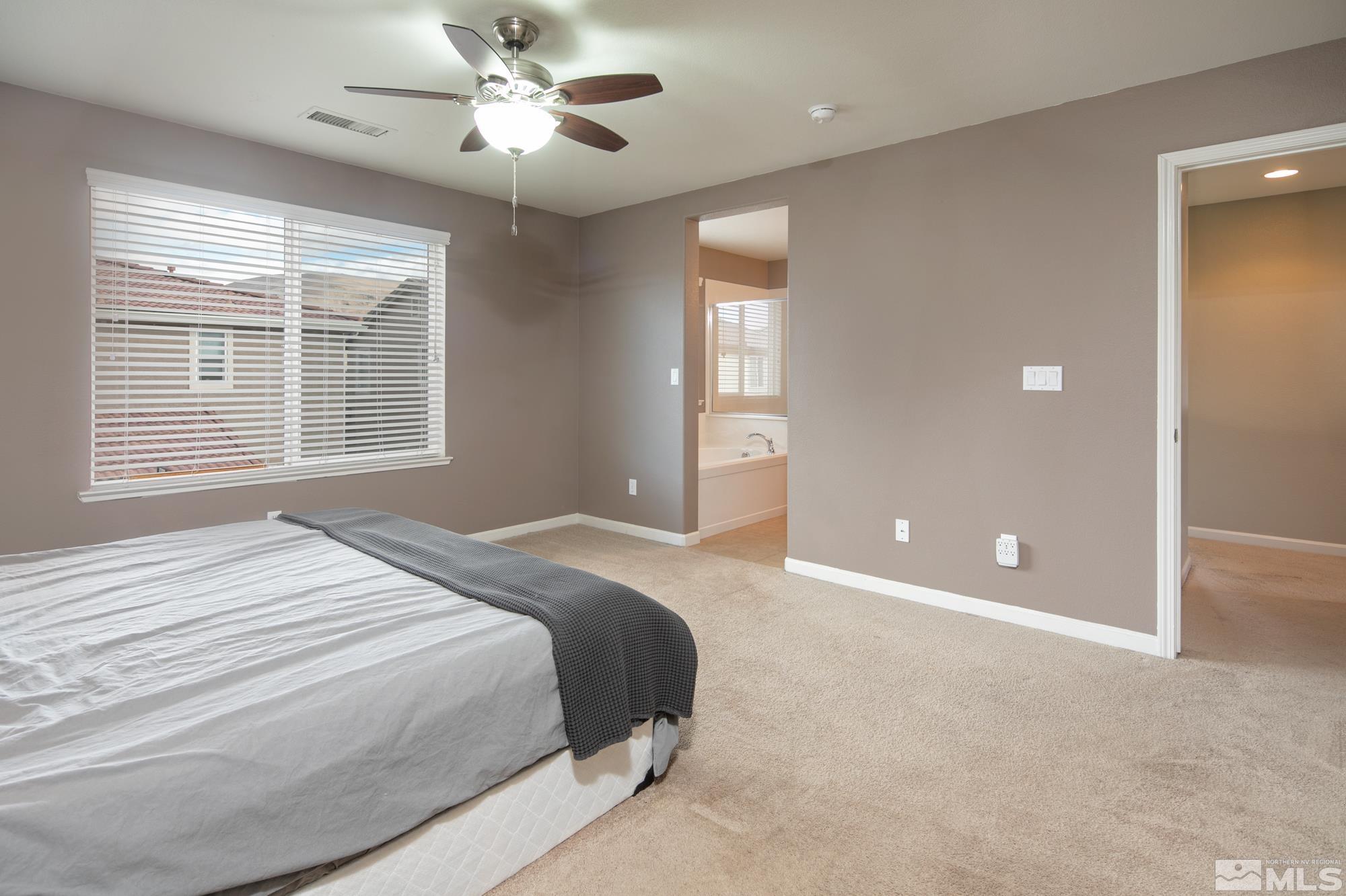 2093 Waterhouse Road Reno, NV 89521 - Photo 23 of 30 a bedroom with a large bed and a chandelier fan