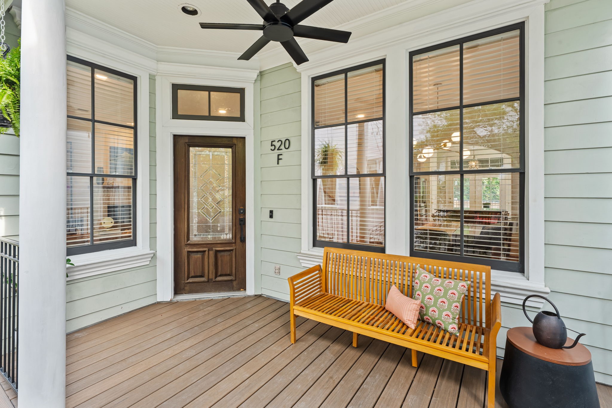 520 Oxford Street, Unit F Houston, TX 77007 - Photo 2 of 38 This wraparound covered porch highlights the home's architectural craftsmanship including a bay-style window arrangement, decorative trim work, and a beadboard ceiling creating an inviting space that seamlessly blends indoor comfort with outdoor living. The composite deck surface and ceiling fan make it a comfortable spot in every season.