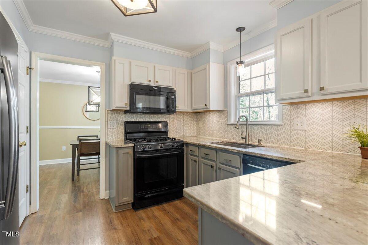 4725 Sinclair Drive Raleigh, NC 27616 - Photo 14 of 36 a kitchen with granite countertop a stove a sink and a microwave