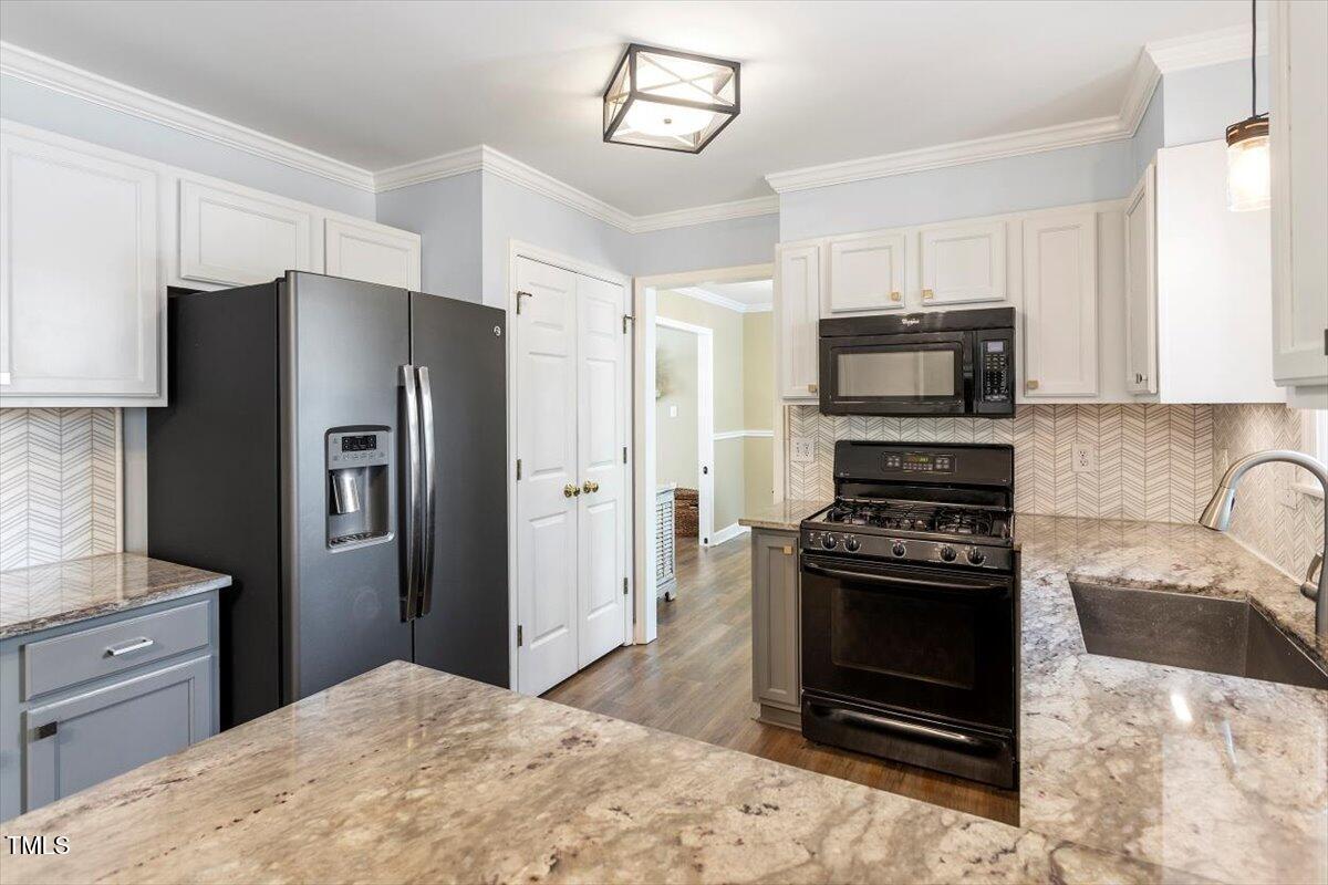 4725 Sinclair Drive Raleigh, NC 27616 - Photo 15 of 36 a kitchen with granite countertop a refrigerator stove and sink