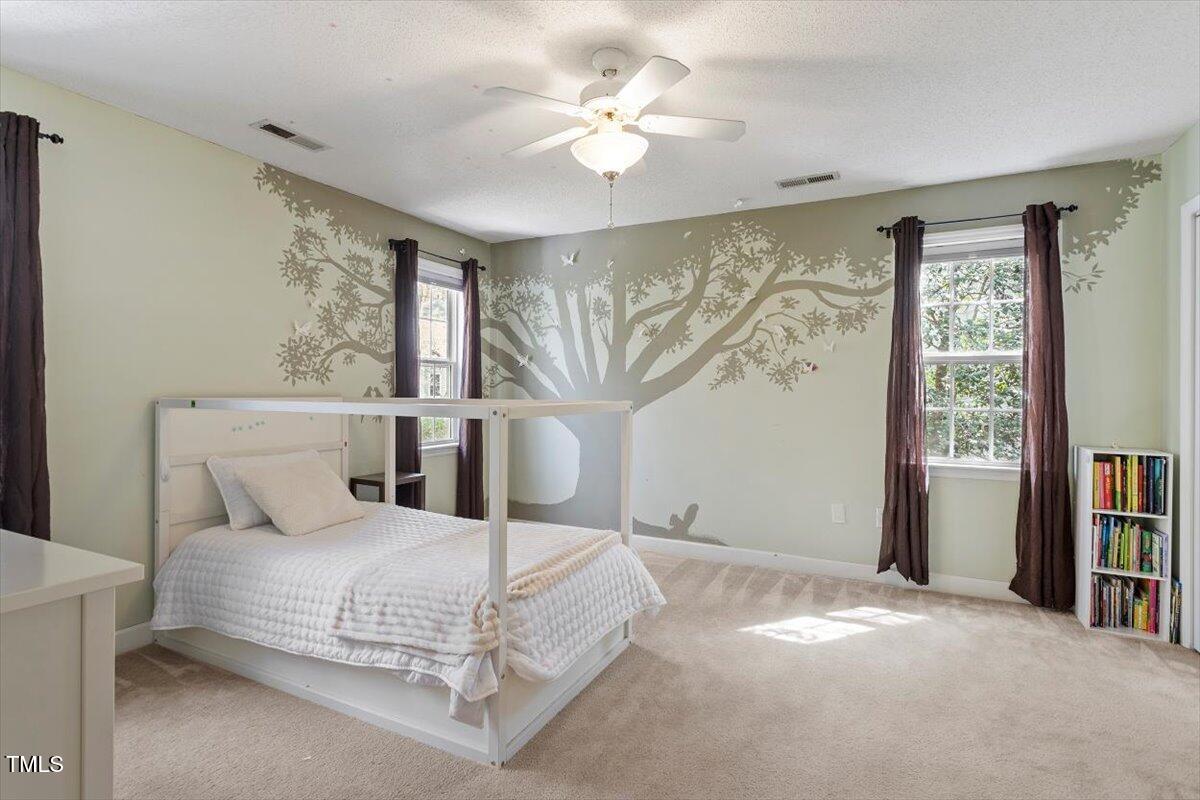 4725 Sinclair Drive Raleigh, NC 27616 - Photo 22 of 36 a bedroom with a large bed and a chandelier fan